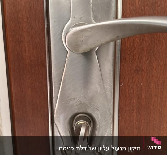 ידית דלת מתכתית עם מנעול על דלת עץ